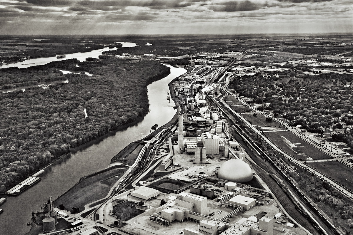 A wooded Joyce Island (left) and the Archer Daniels Midland Company’s Cogeneration Plant, Clinton, IA.